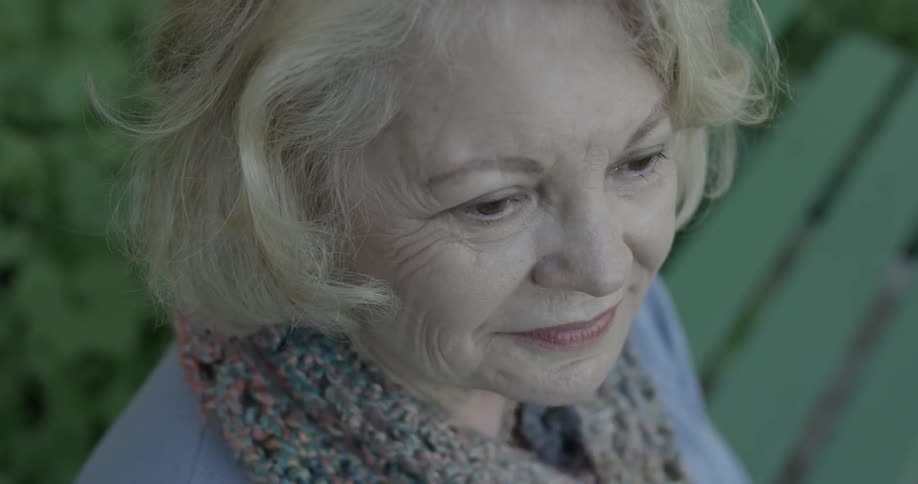 Caucasian woman approximately age 65th, looking around coherently close up
