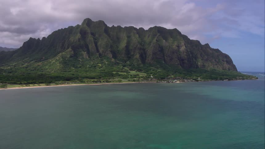 Water ripples in sea below mountain range
