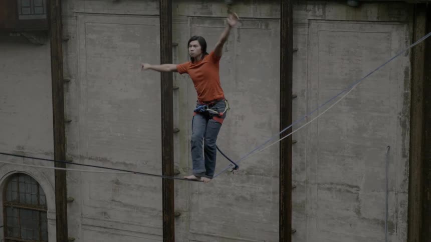 A man does a dangerous tightrope walk