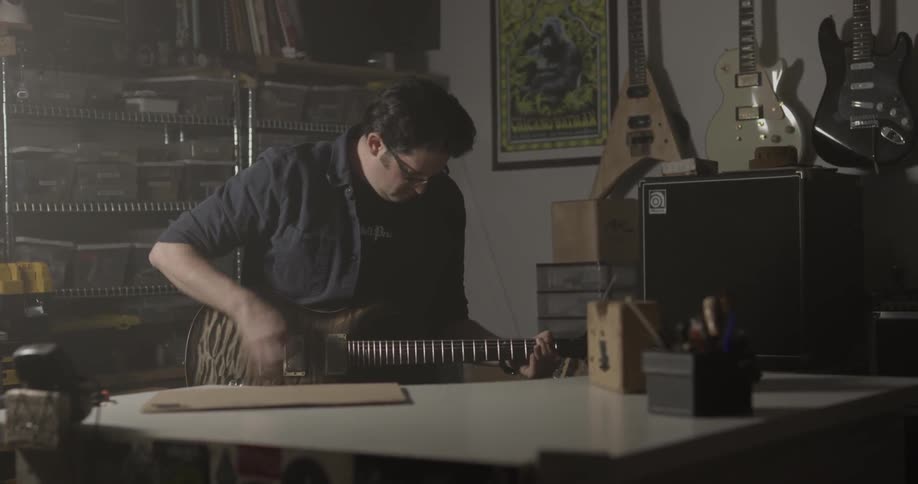 A man is playing guitar indoors