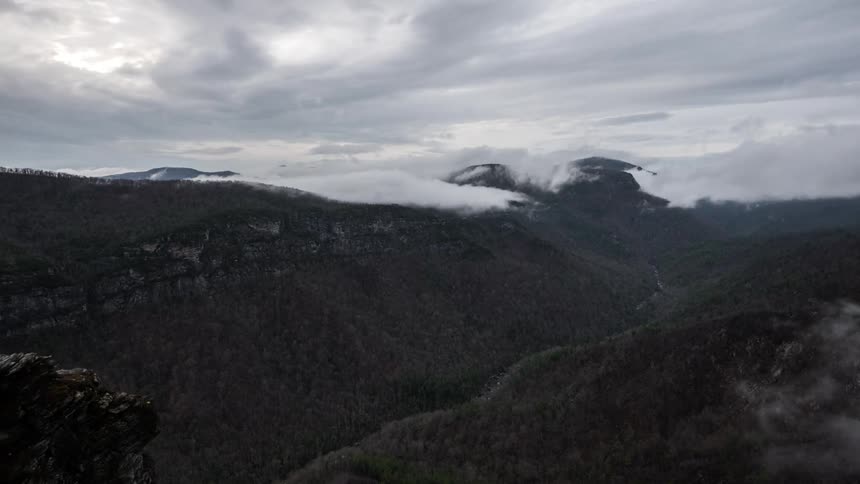 Timelapse of clouds floating over a hilly landscape