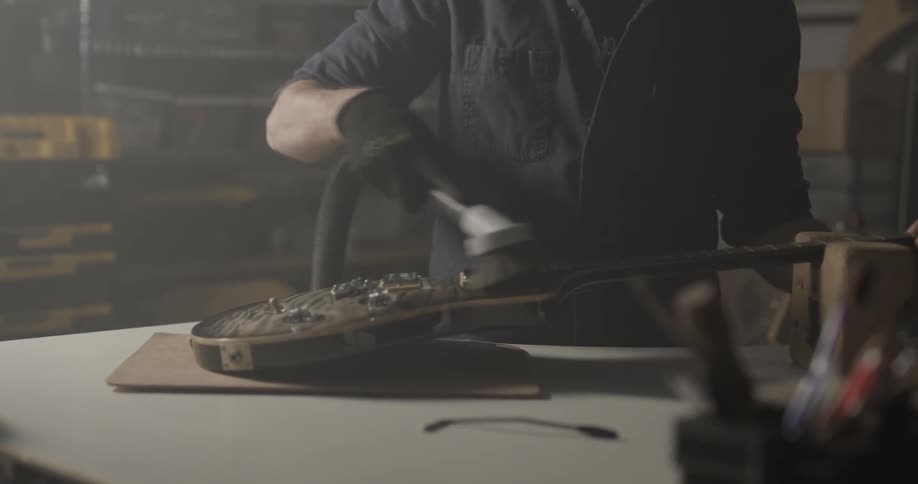Man Making Guitar In Workshop