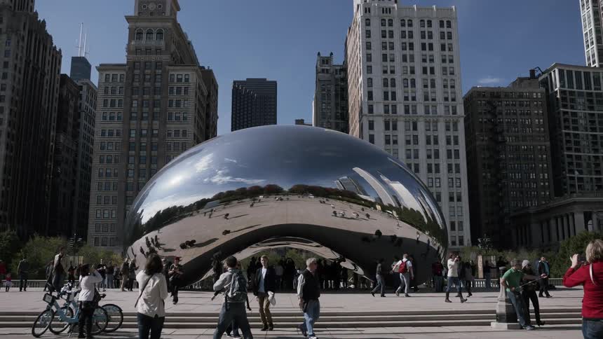 People walking around the cloud gate or bean sculpture in chicago