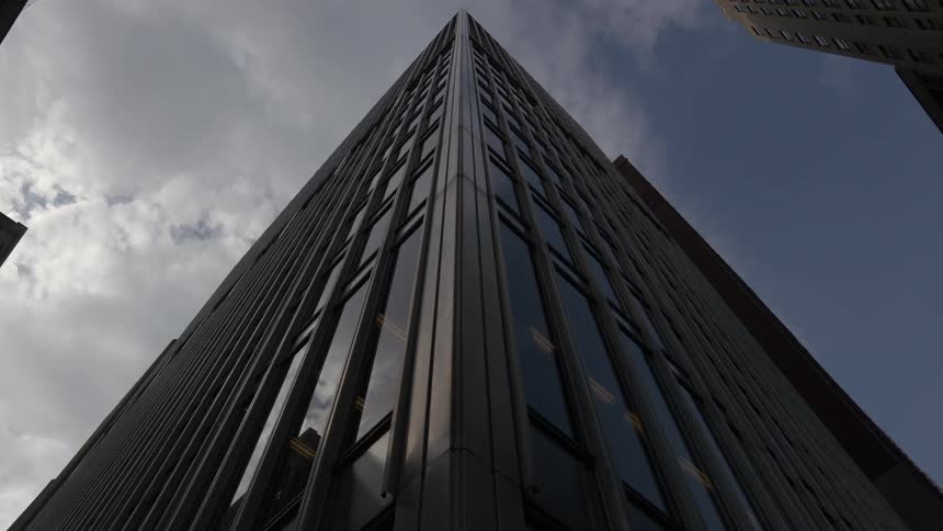 An upward view of a skyscraper on a cloudy day