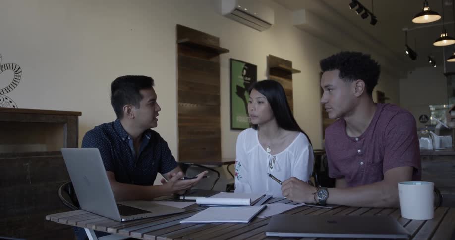 Three young adults working together on the computer