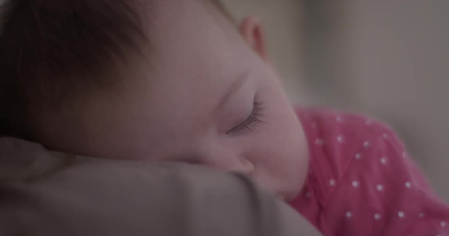 A baby sleeps on someone's shoulder