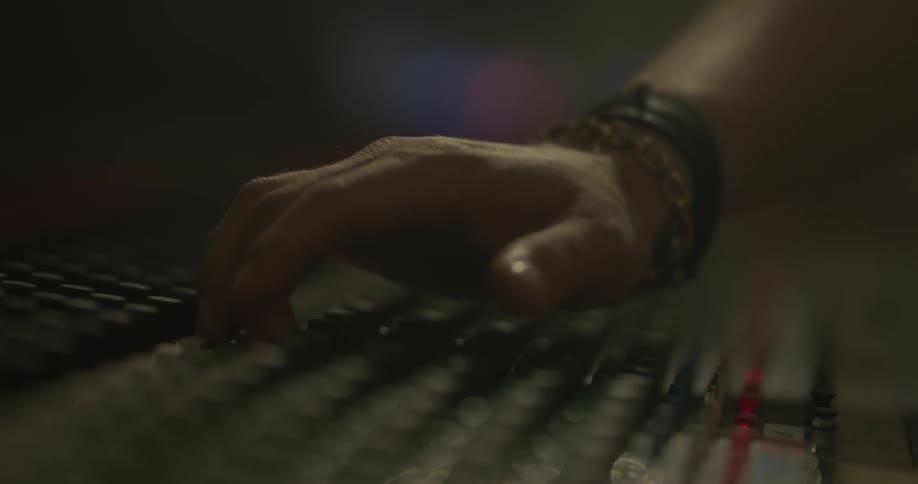 Someone adjusts knobs on a mixing board