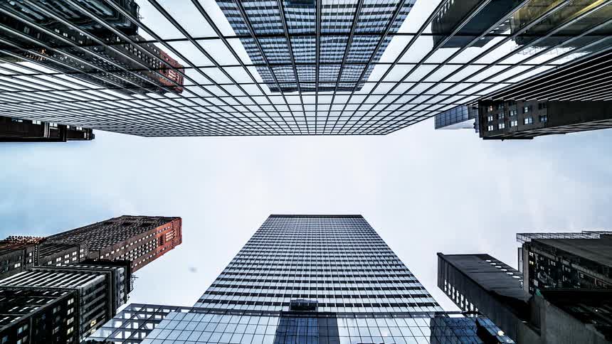 Time lapse of the upwards view of a tall building looking at the sky on a sunny but cloudy day