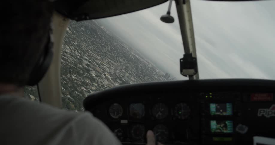 Pilot flying plane banking left over city