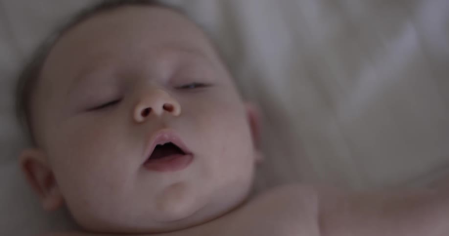 Newborn baby turns and looks at camera