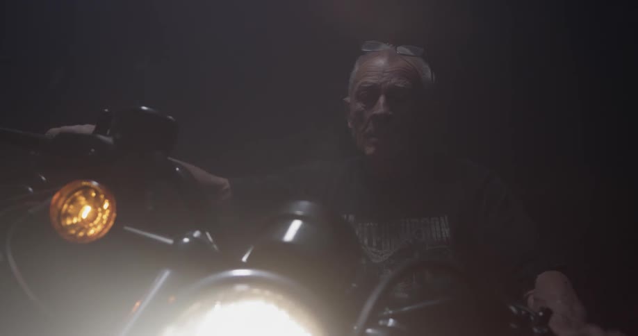 Man starts up motorcycle and turns on headlight
