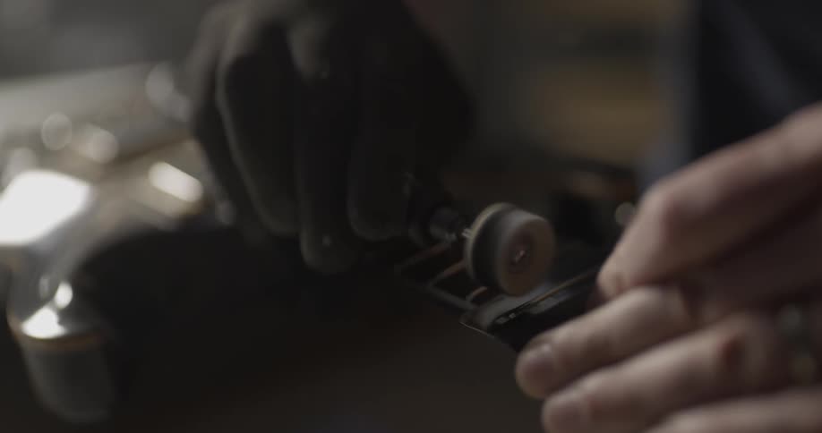 Close up of hands polishing neck of guitar