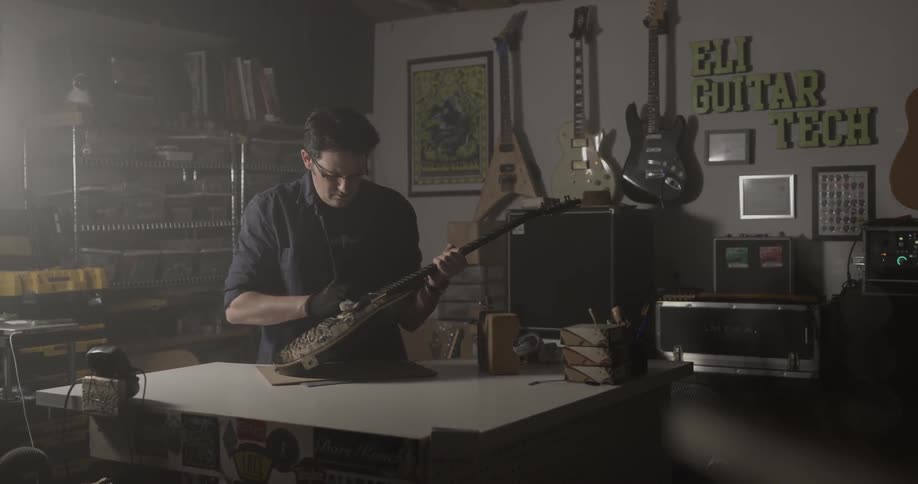 Man wipes down guitar in music store