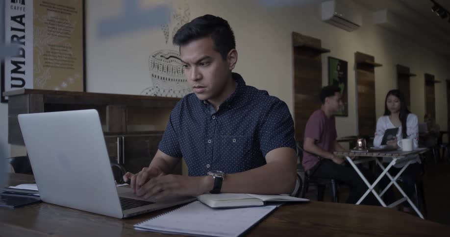 A man types on a lap top