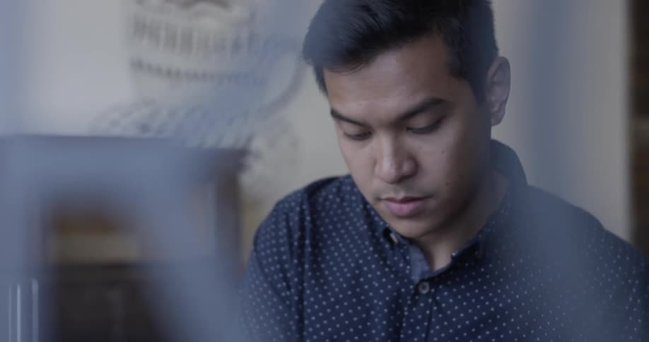 A man is sitting at a cafe table