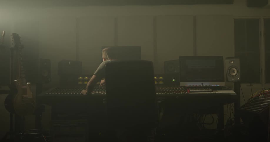 Man adjusts setting on audio mixer