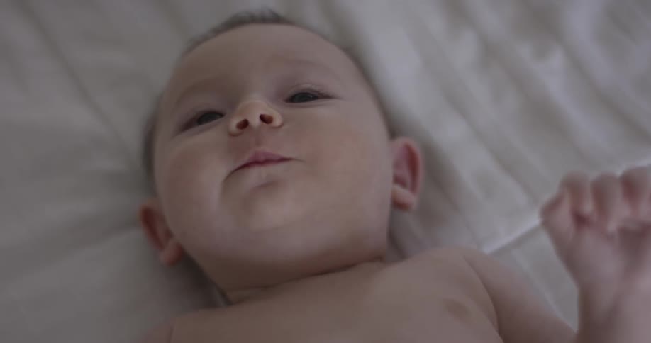 Newborn baby lies on bed