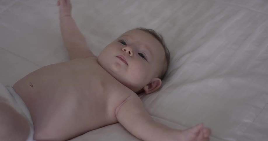 Baby lays on bed and squirms around
