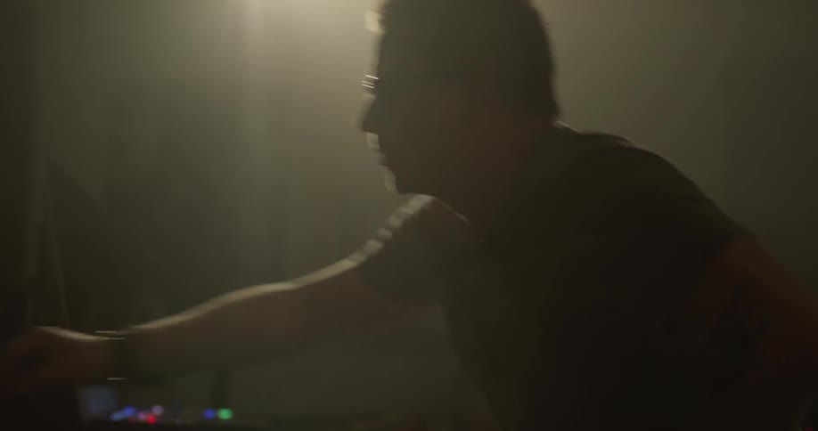 Man adjusts setting on audio mixer