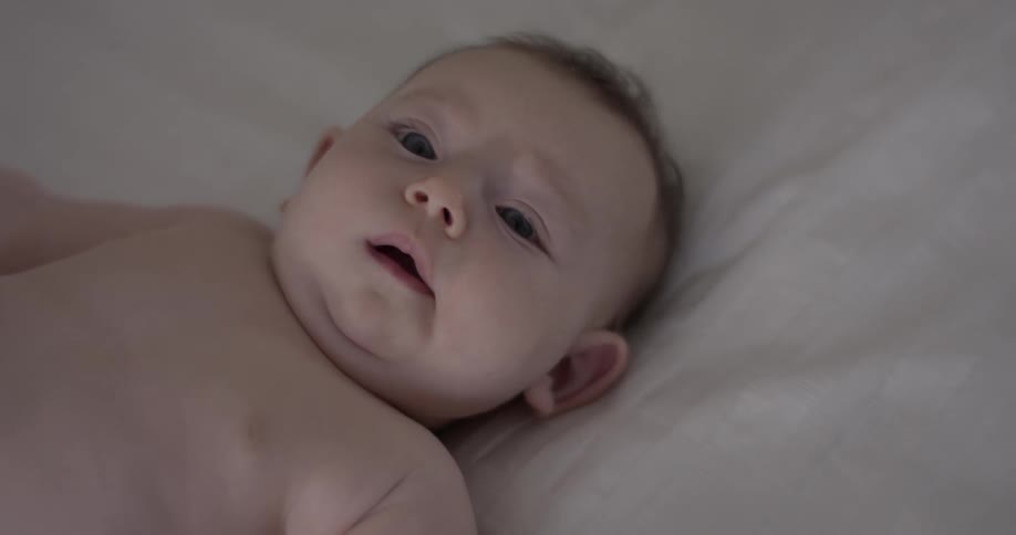 A baby looks around while laying down