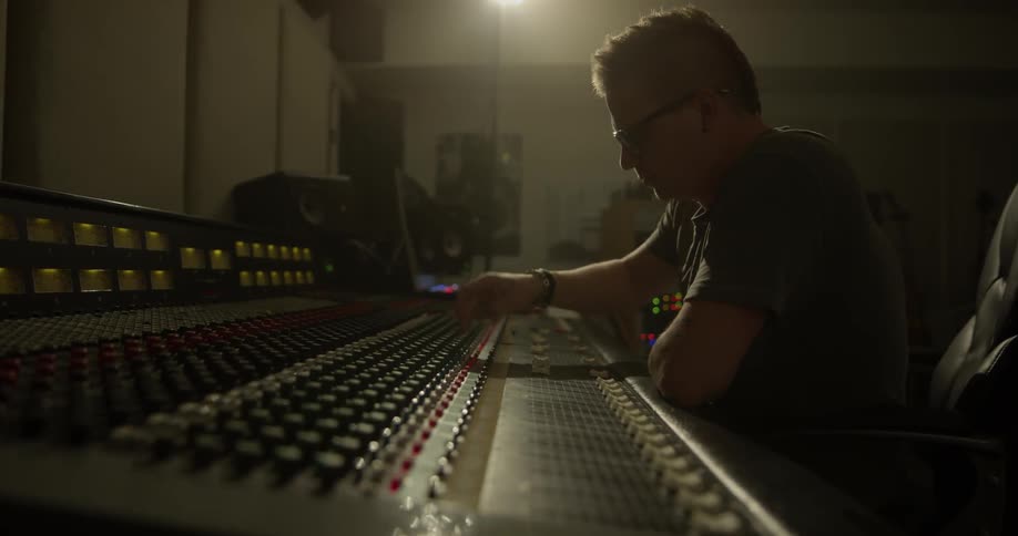 Man modifies settings on audio mixer