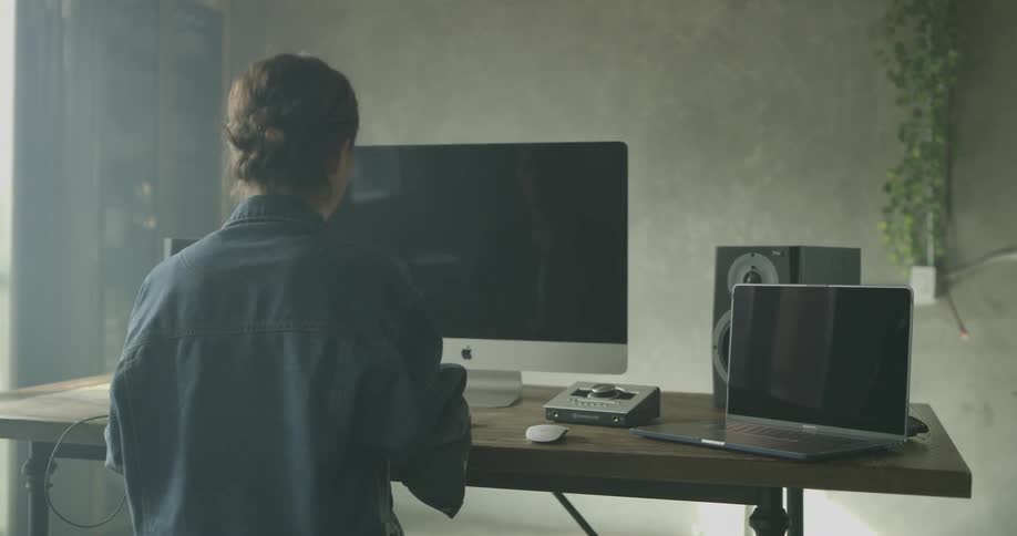 Woman sits at computer and types
