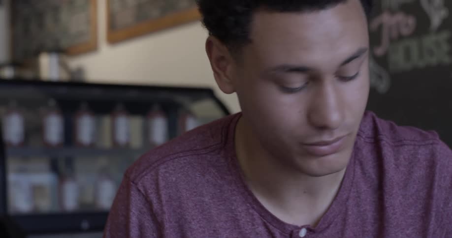 Man writes on paper while talking to someone else