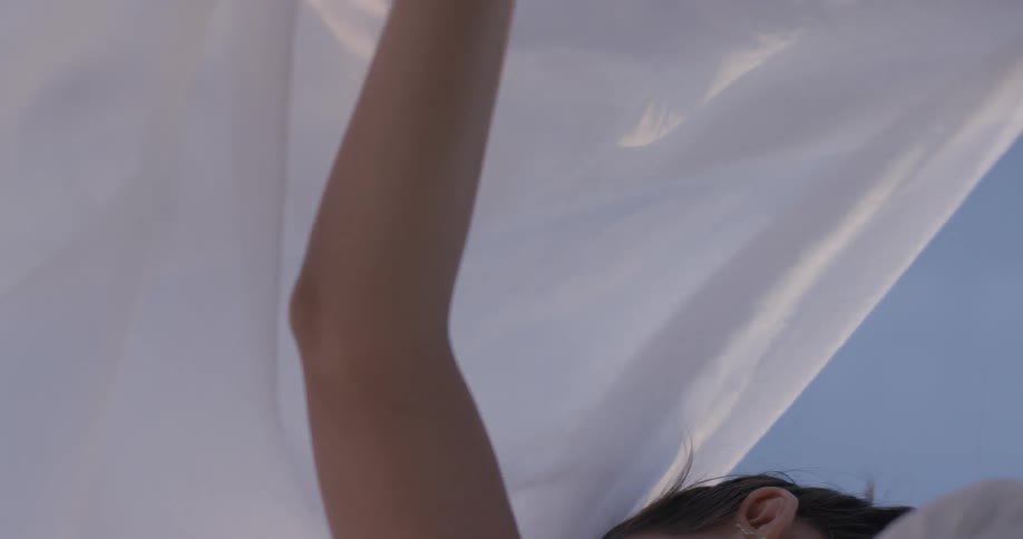 Woman dances while holding cloth aloft