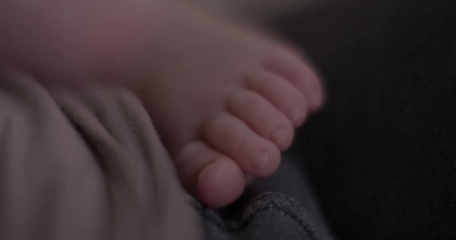 Baby's foot resting on someone else