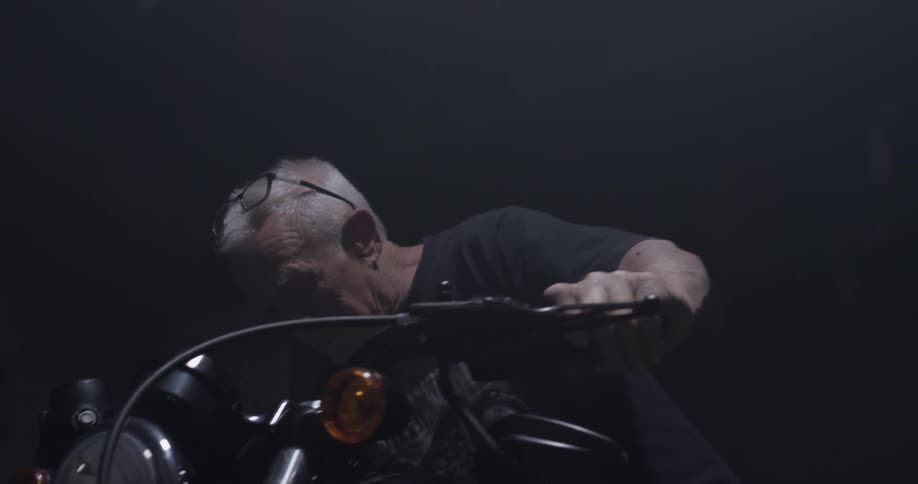 Man sits on motorcycle and turns lights on