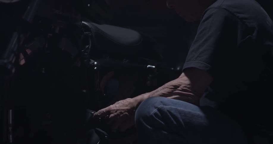 A man is using a wrench on a motorcycle
