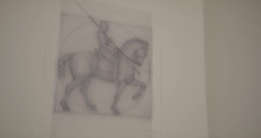 A drawing of a man riding a horse hangs on a white wall