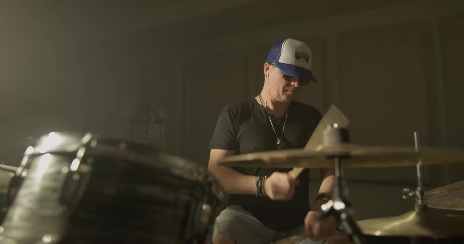 Man plays drums indoors