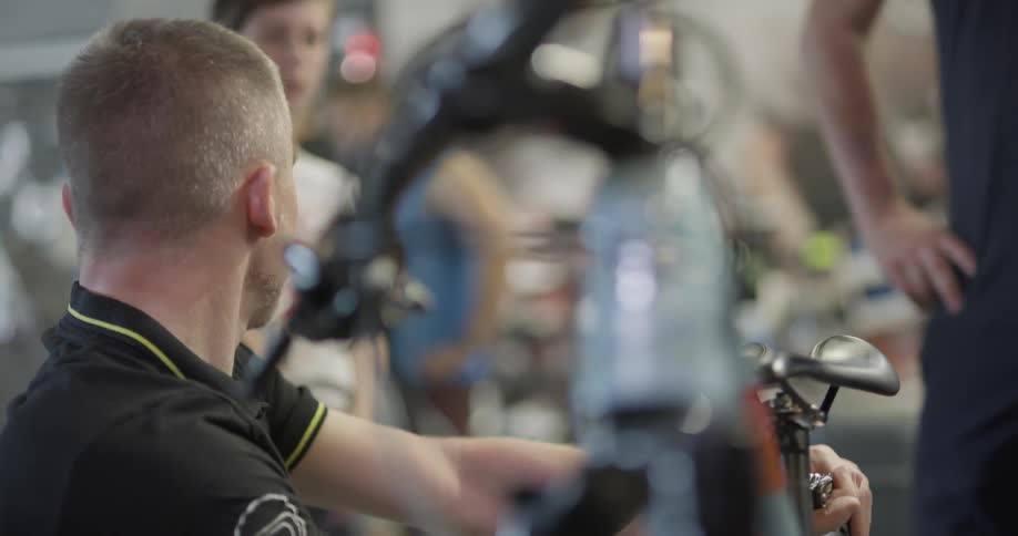 Kneeling max works on bike inside shop