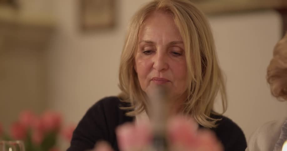 A woman talks while dining with others around a table