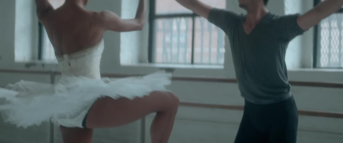 A man and woman ballet dance in a studio room