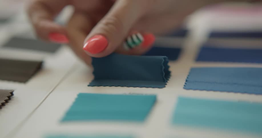 A woman is looking at different fabric colors