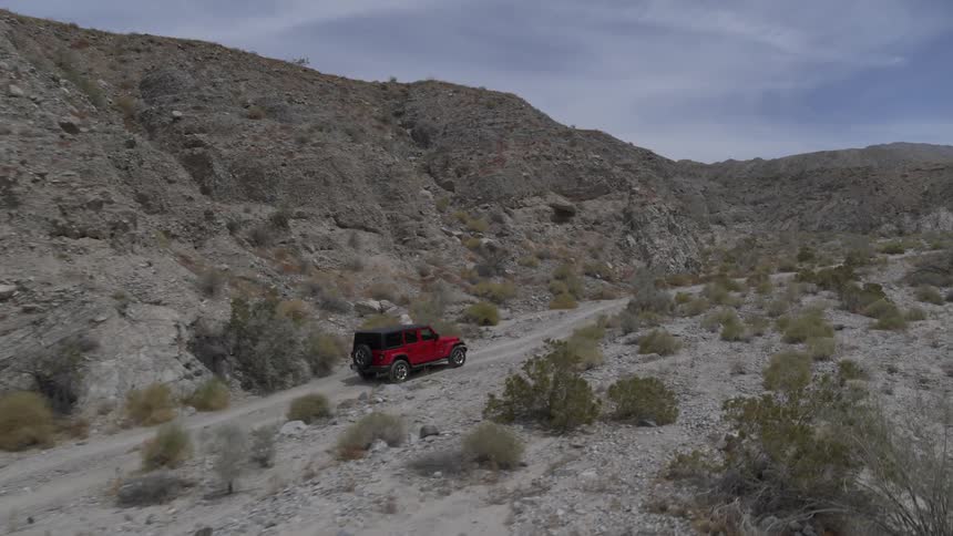 Red jeep driving through the desert