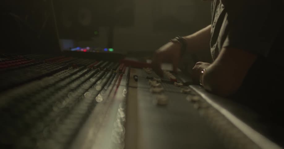 Man's profile in a dark room using sound board
