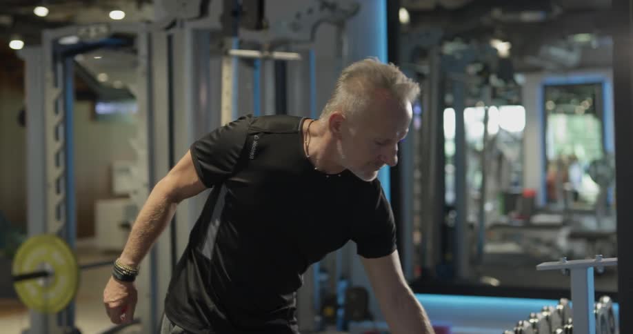 A man carrying weights in a gym