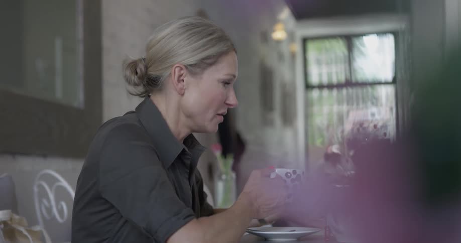A woman is talking while holding a cup