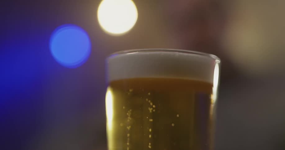 A person setting a beer on a table