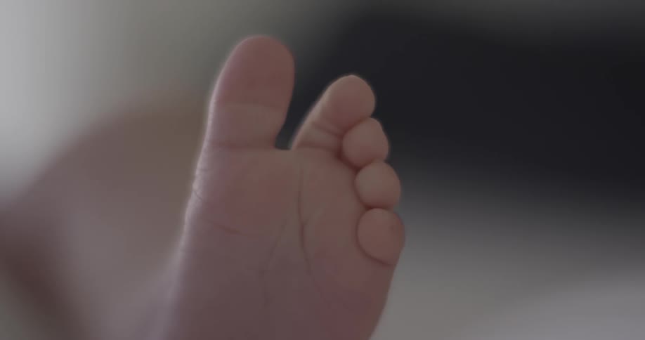 A baby moves its foot and toes