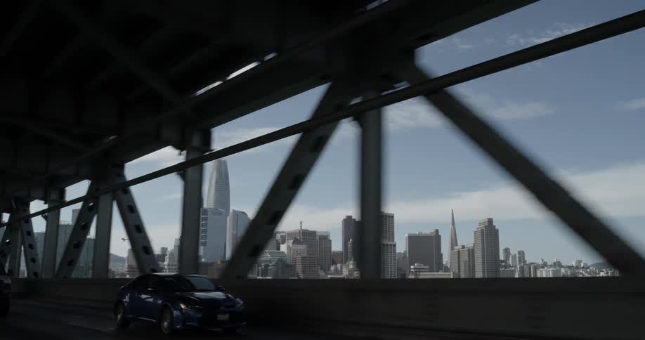 People driving on a bridge outside of a city