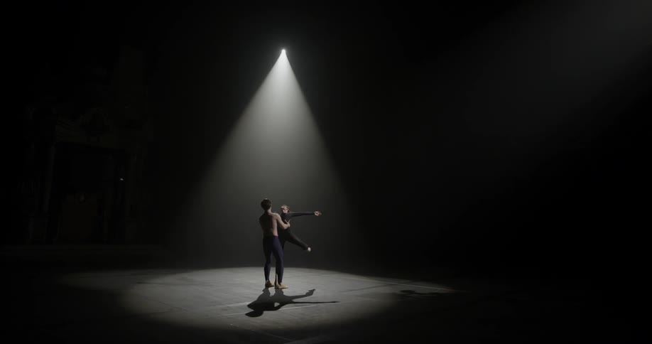 Male and female ballet dancers spinning on a stage