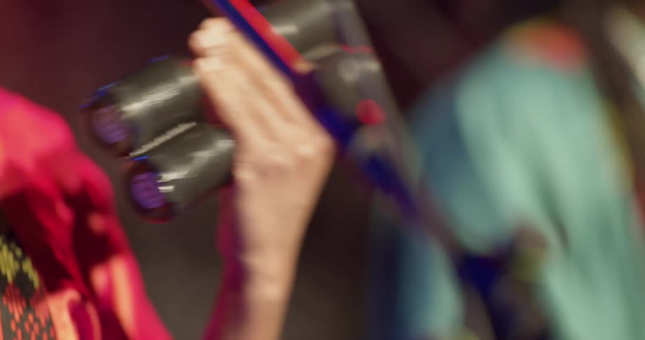 A musician shakes a percussion instrument