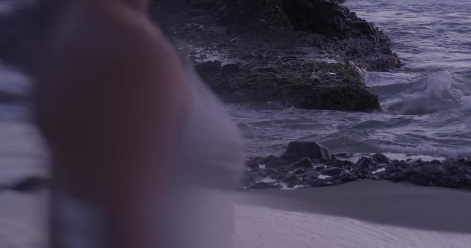 Woman standing on a rock lined beach