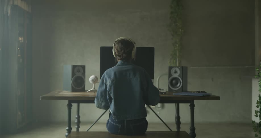 A person sitting at a table puts on headphones
