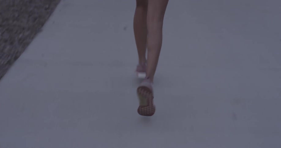 A woman jogs along a sidewalk