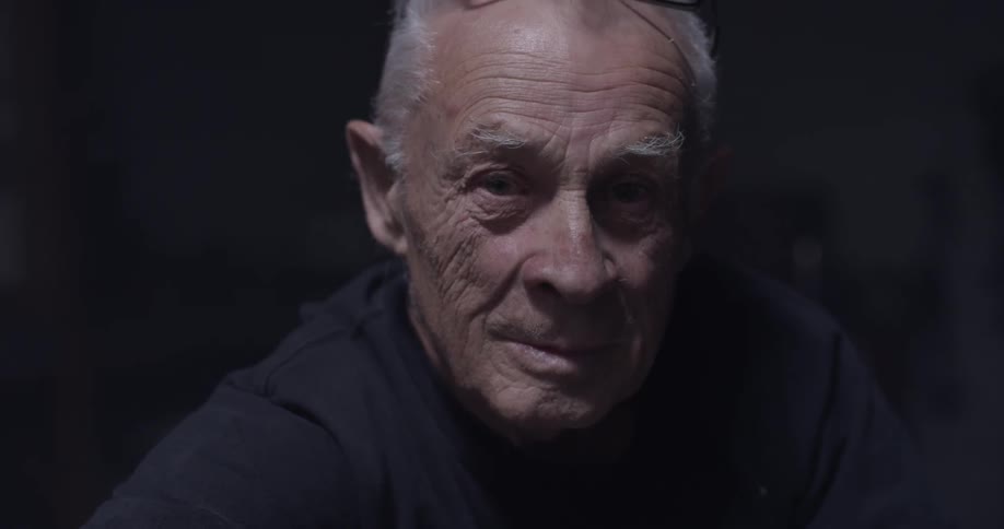 Elderly man looks into camera